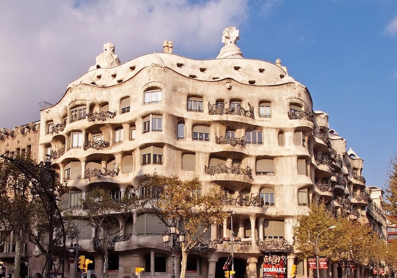 A building with unique architectural design, featuring balconies with sculptures and a curved facade. 4