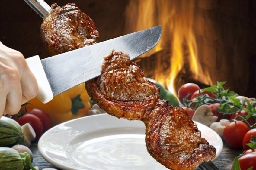 A person carving a roasted meat on a wooden cutting board. 2