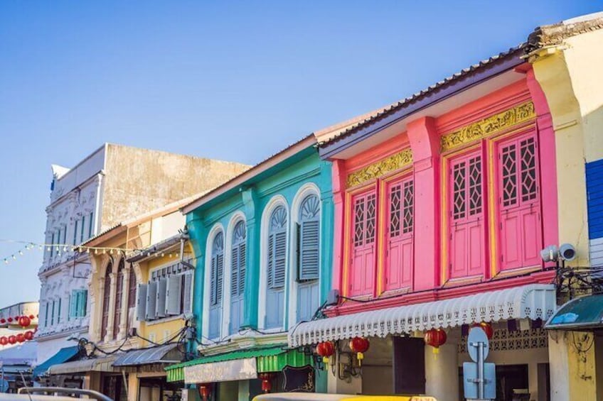A row of colorful buildings with traditional windows and awnings. 2