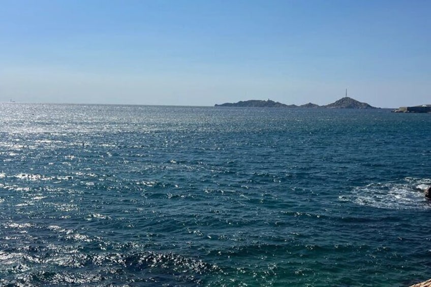 Een rustige zee met een eiland in de verte en een heldere lucht. 4