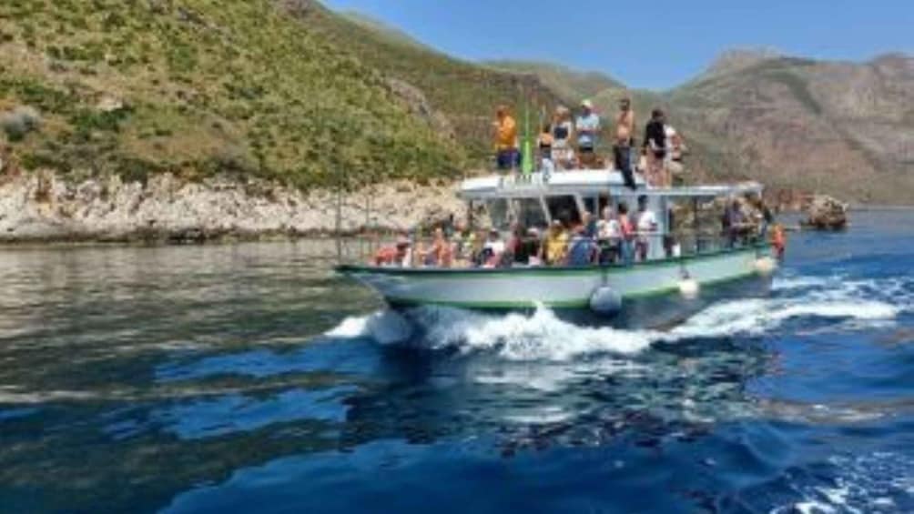 A boat with passengers on a river surrounded by hills. 2
