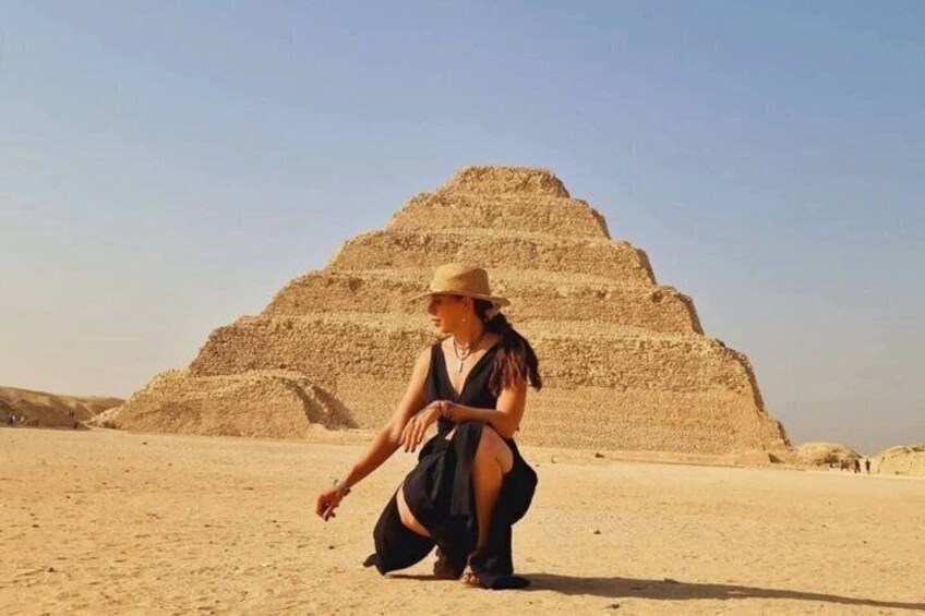 Eine Person in der Wüste vor einer großen Pyramide. 2