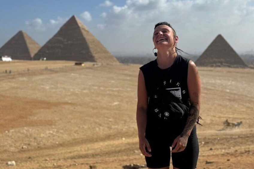Eine Person steht vor den Pyramiden von Gizeh. 1