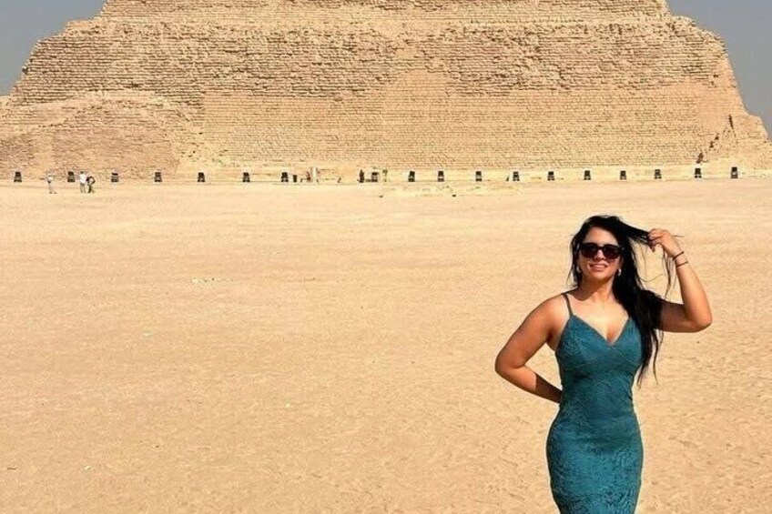 Eine Person steht in einer Wüste vor einer großen, alten Struktur im Hintergrund. 4