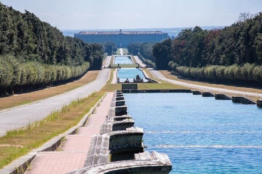 Un canale con un sistema di chiuse, circondato da vegetazione e un ponte sullo sfondo. 1