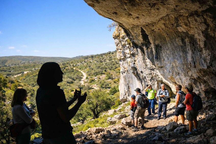 A group of hikers on a rocky trail with a mountainous landscape in the background. 2