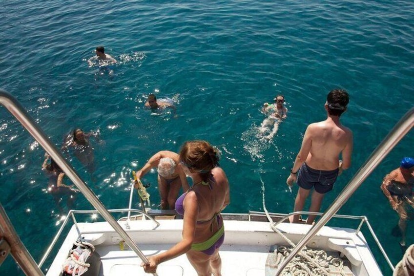 People swimming in a body of water from a boat. 1