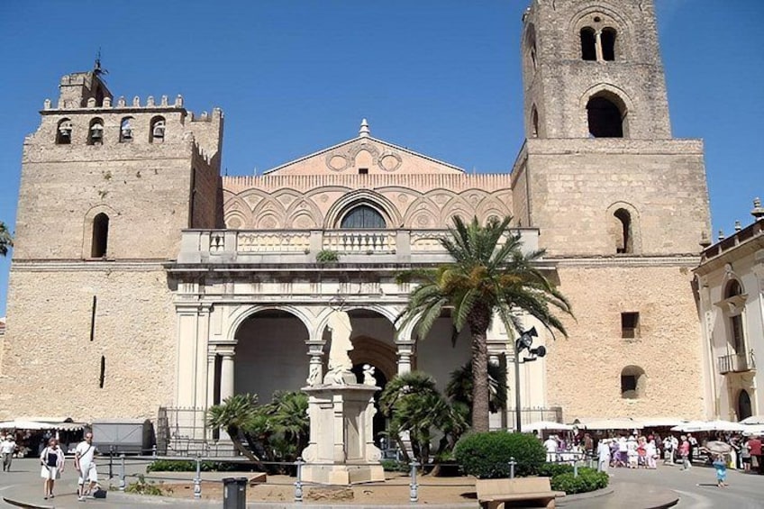Un bâtiment historique doté d’un clocher, d’une entrée en arc de cercle et de palmiers. 1