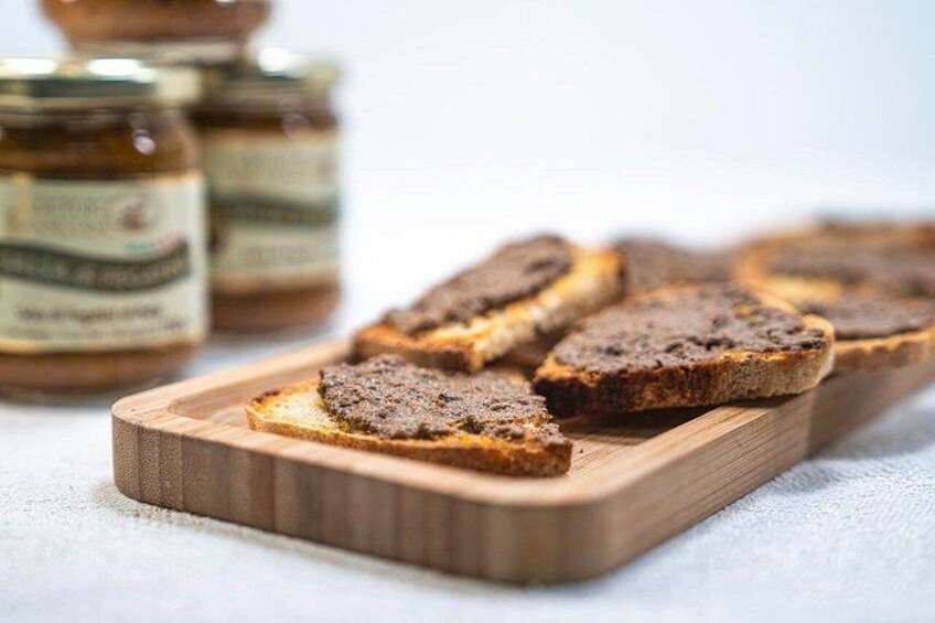 Slices of dark bread on a wooden board with jars of spread in the background. 3