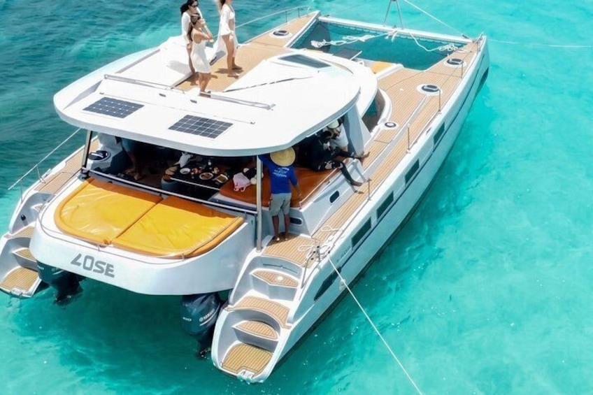 A yacht with a covered deck, a wakeboard, and a wakeboarder. 1