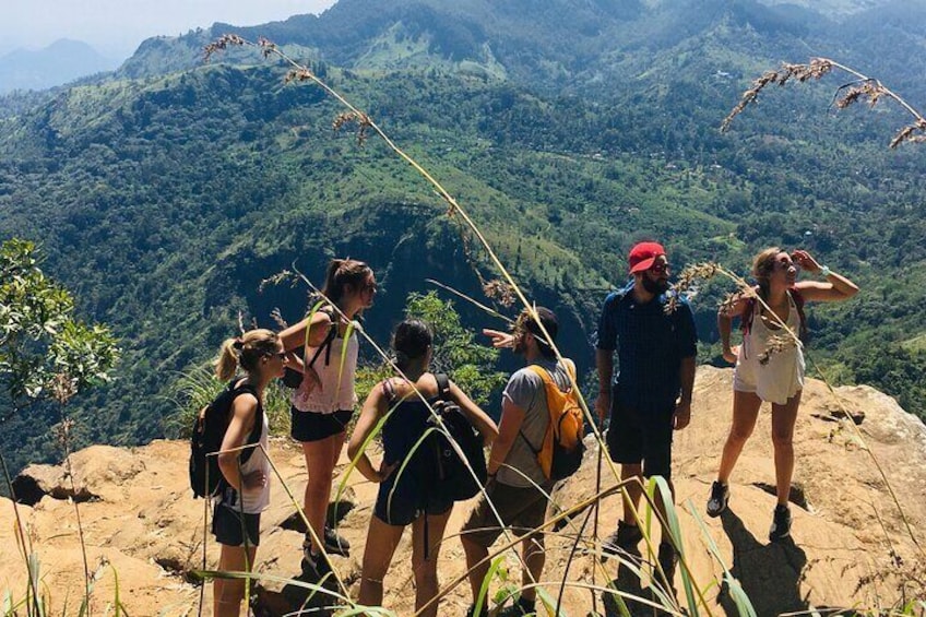 A group of hikers on a mountain trail with lush greenery in the background. 2