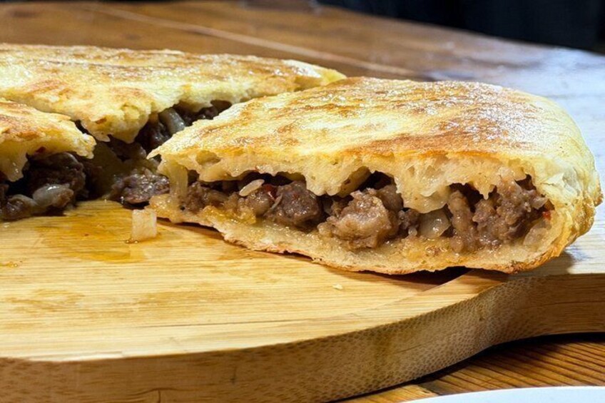 A stuffed pastry cut in half on a wooden board. 3