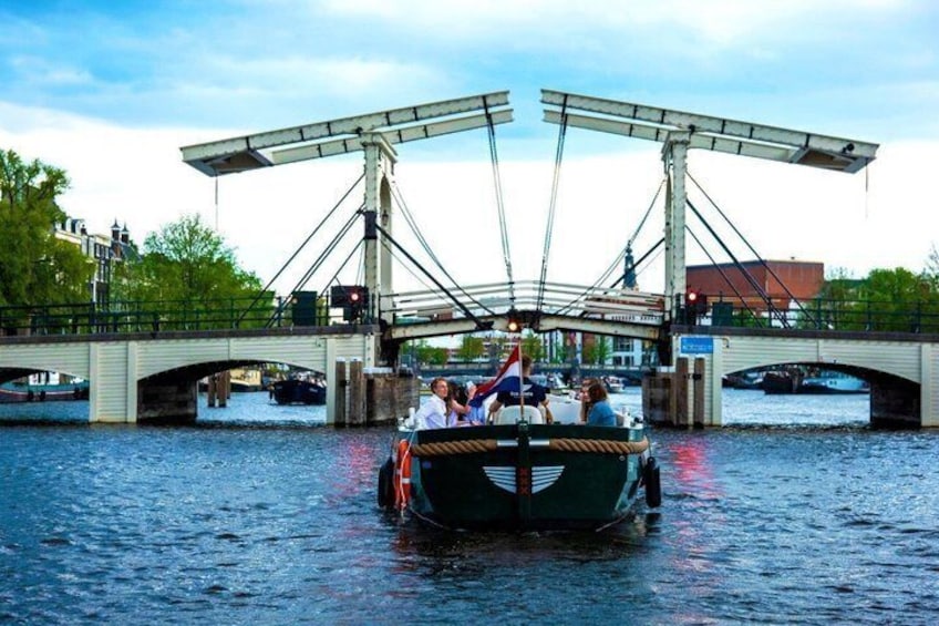 En båt med passagerare på en kanal under en bro. 2