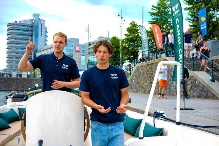 Två personer i en båt med en stadsbild i bakgrunden. 4
