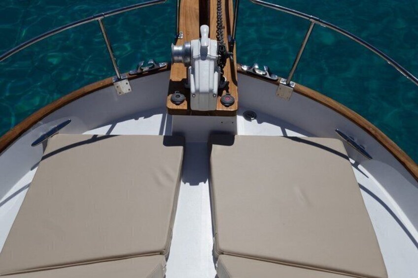 La prua di una barca con un ponte in legno e un tendalino beige. 2