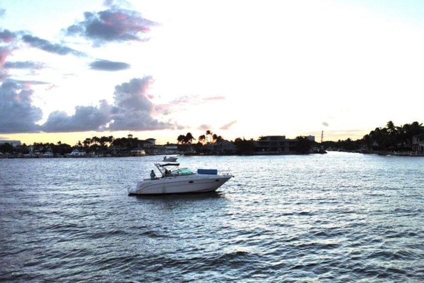 A boat on calm water with a sunset in the background. 3