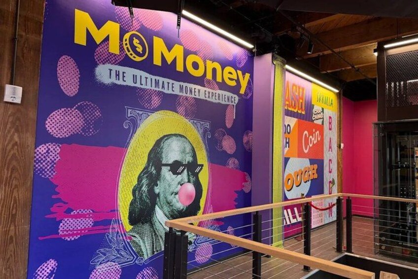A colorful mural with the text 'Mo Money' and 'The Ultimate Money Experience' on a wall. 1