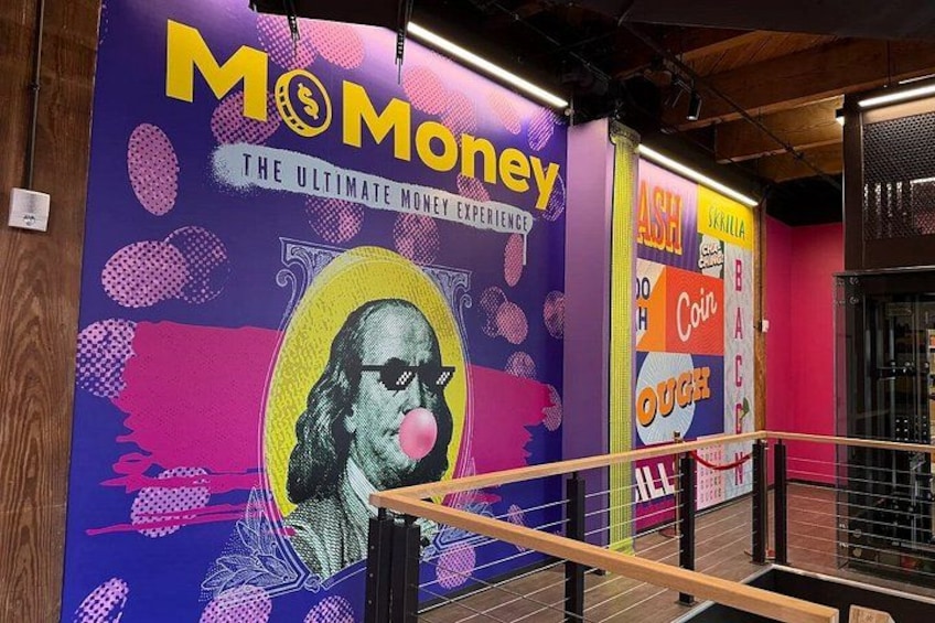A colorful mural with the text 'Mo Money' and 'The Ultimate Money Experience' on a wall. 1