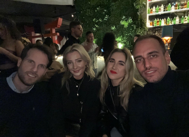 A group of people at an indoor event with a bar in the background. 5