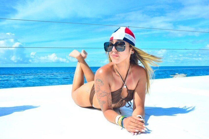 A person lying on a boat with the ocean in the background. 5