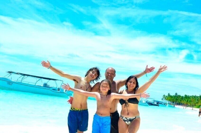 A group of people on a beach with a boat in the background. 2