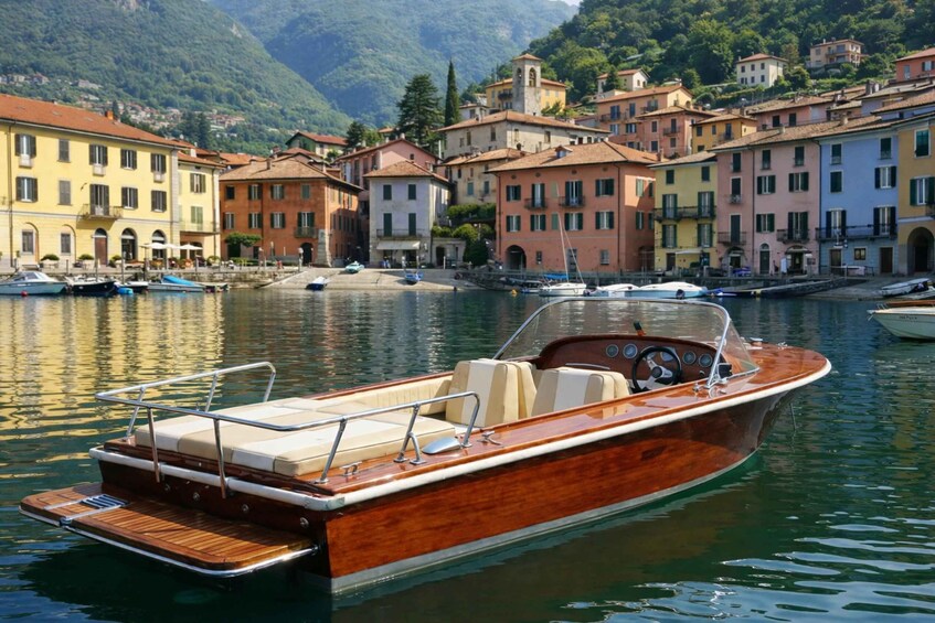 A wooden boat docked at a marina with colorful buildings in the background. 3