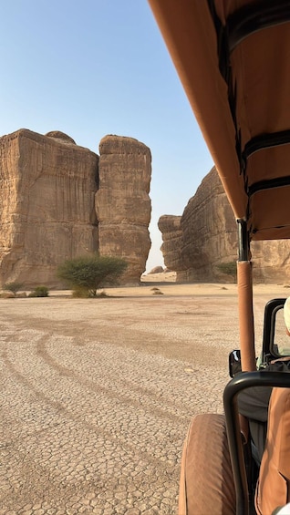 A desert landscape with rock formations and a vehicle. 5