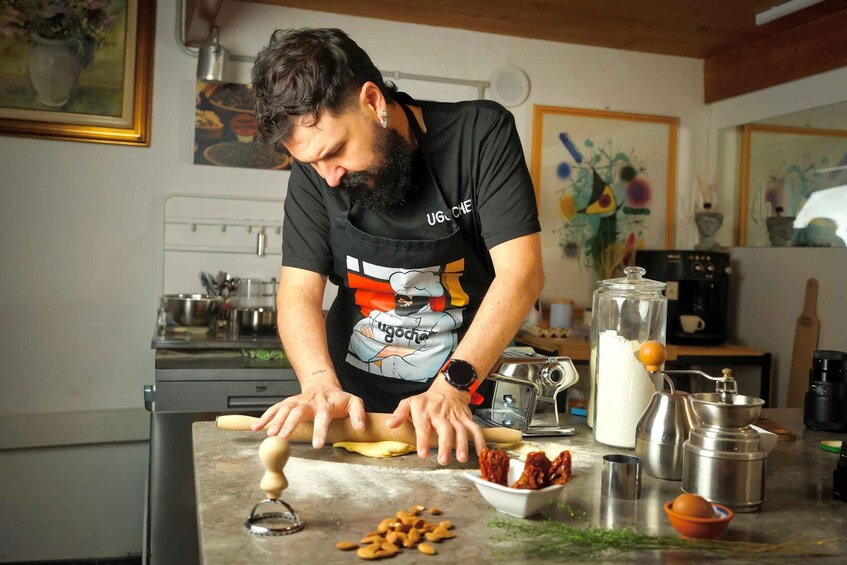 A person rolling dough on a kitchen counter with various kitchen items around. 3