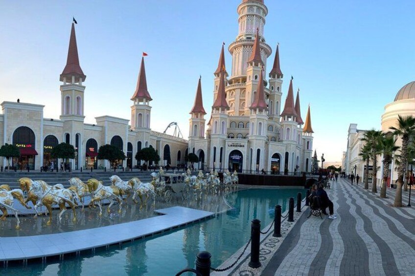 A large building with multiple spires, a central fountain, and a pool. 4