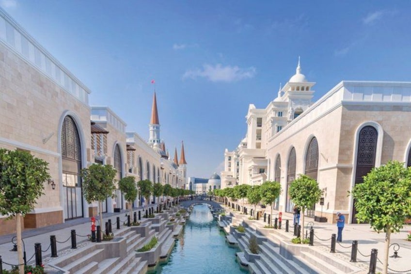 A canal lined with trees and buildings with domes and spires. 2