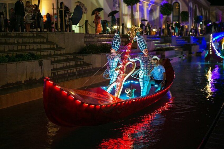 Una góndola con adornos iluminados en un canal por la noche. 4