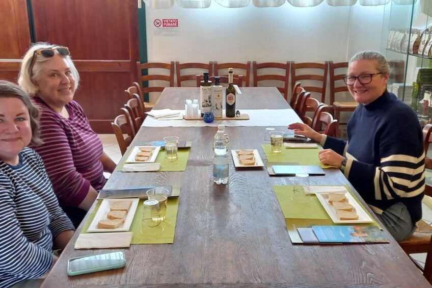 Un tavolo da pranzo in legno con sottopiatti, piatti, bicchieri e una bottiglia di vino. 2