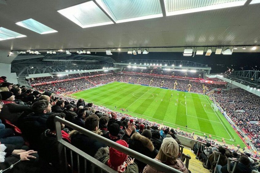 A stadium filled with spectators, a football pitch, and floodlights. 5