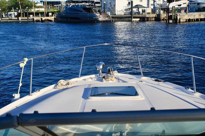 La proa de un barco con una vista despejada del agua y yates amarrados al fondo. 4