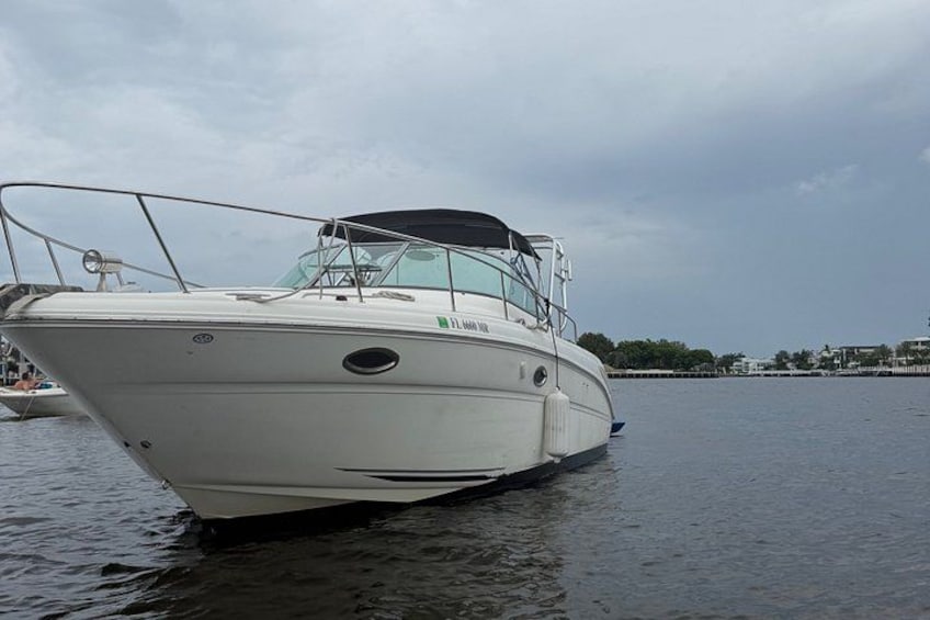 Un barco blanco con camarote y cubierta protegida, amarrado en aguas tranquilas. 2