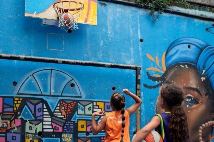 A basketball hoop and a mural on a wall. 3