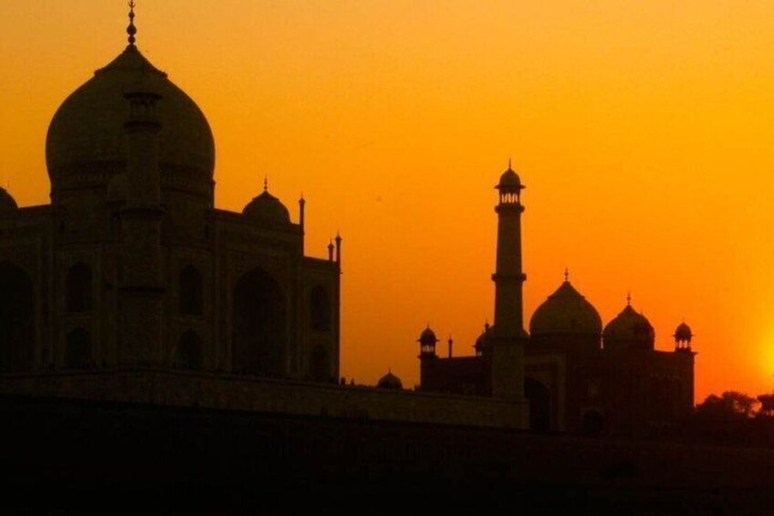 The Taj Mahal at sunset with its distinctive domes and minarets silhouetted against the sky. 2