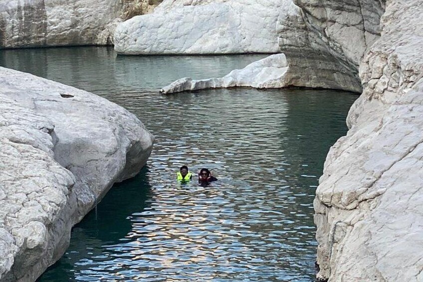 A person swimming in a rocky river surrounded by large boulders. 2