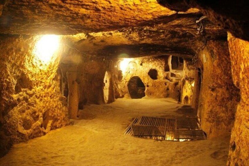 A cave with stalactites, a central chamber, and a light source. 5