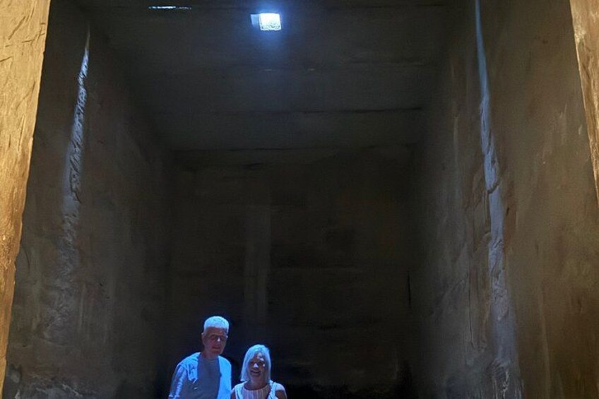 A narrow passageway with a light fixture at the end. 2