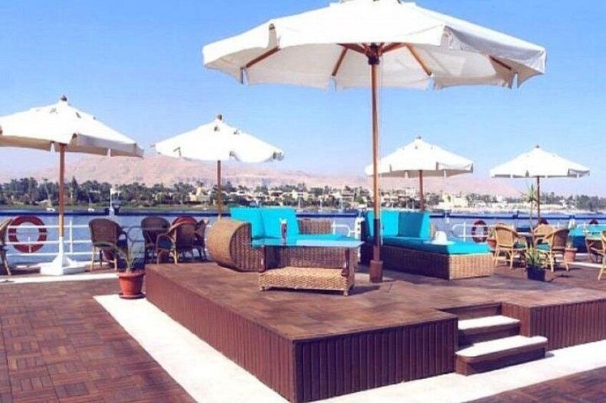A deck with outdoor seating, umbrellas, and a view of the water. 3