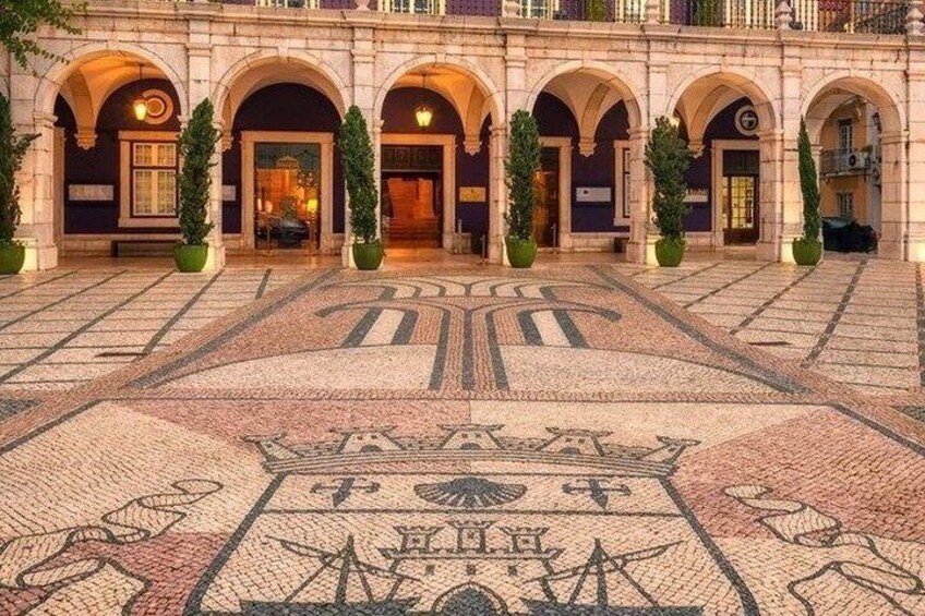 A courtyard with a mosaic floor, arches, and potted plants. 3
