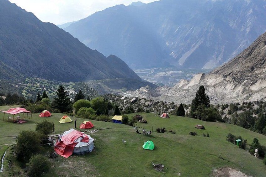 A mountainous landscape with tents and a river. 4