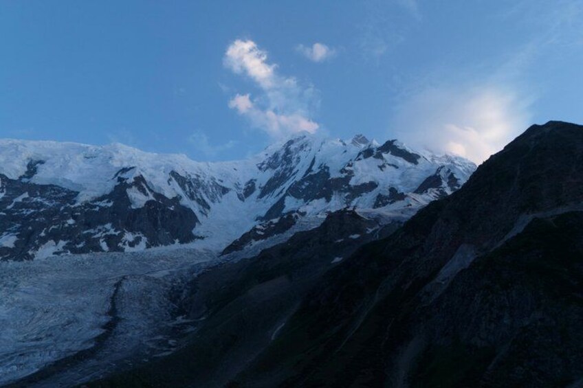 A snow-covered mountain range with rugged terrain and a clear sky. 1