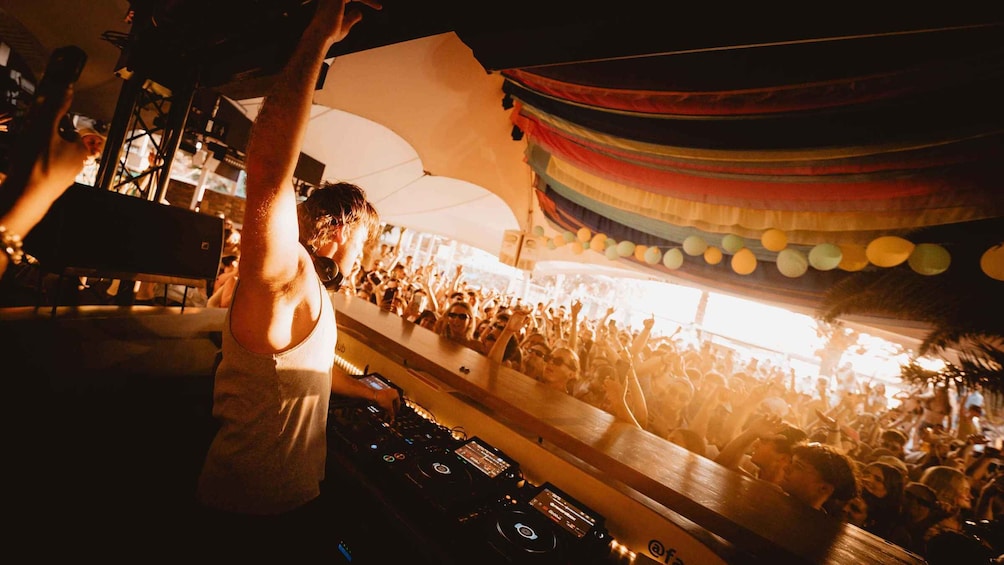 A DJ booth with a crowd in the background. 1