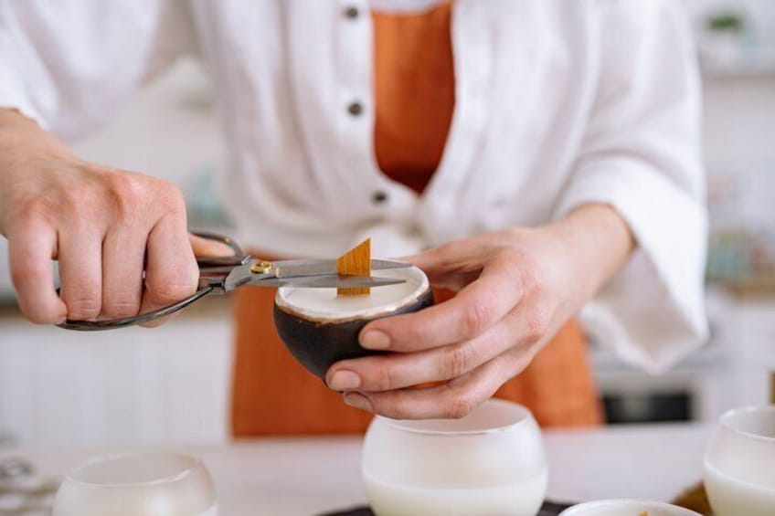 A person using scissors to cut a piece of wood. 4