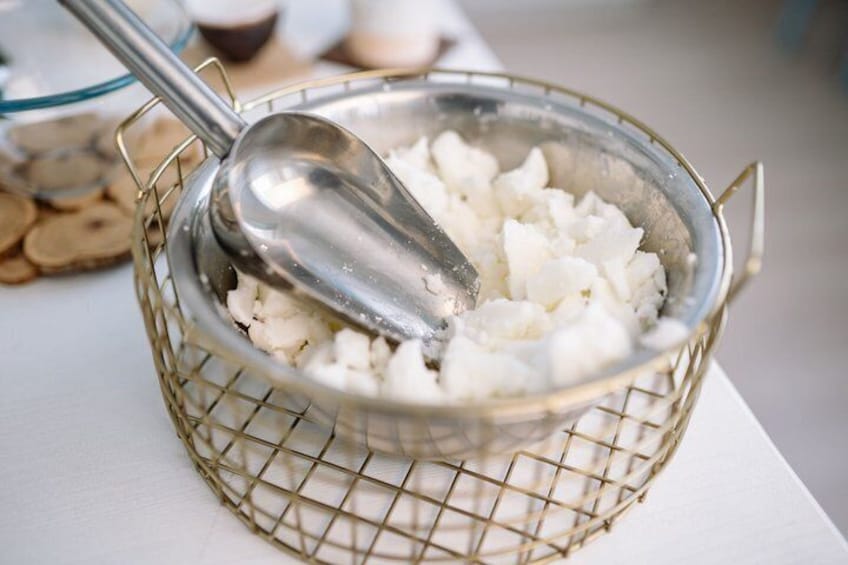 A colander with cubed cheese and a spoon. 2