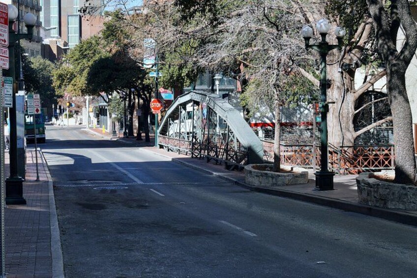 Eine Straße mit einer Fußgängerbrücke, Bäumen und einem Stoppschild. 2