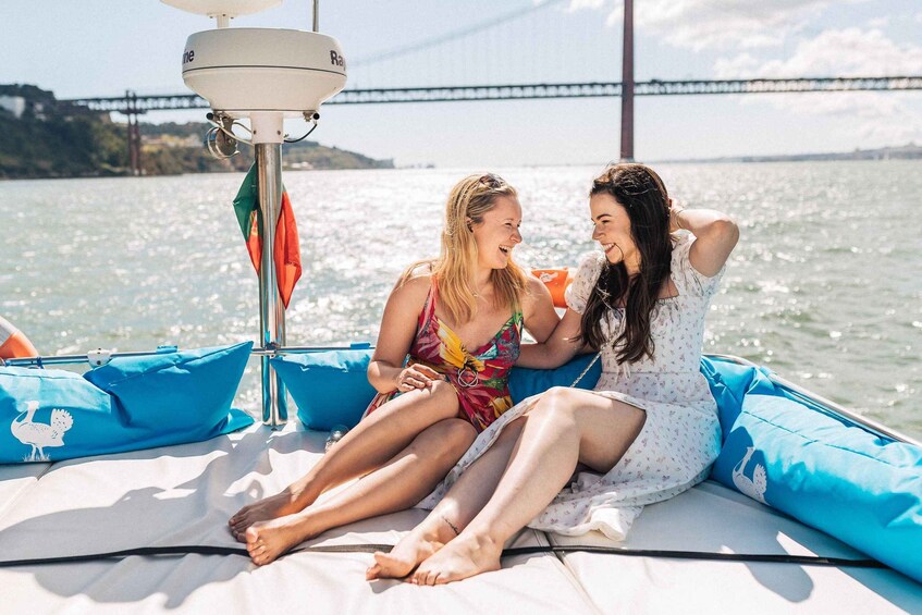 Two people sitting on a boat with a bridge in the background. 1