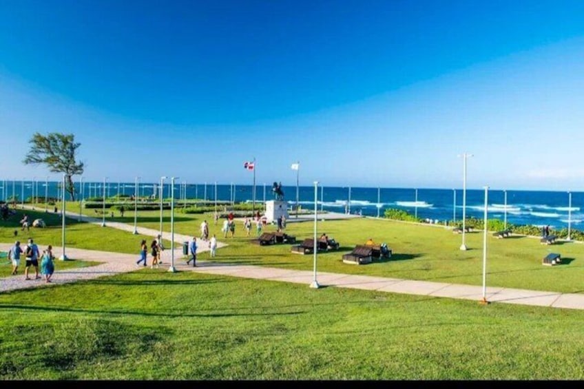 A coastal park with walking paths, grassy areas, and a view of the ocean. 3